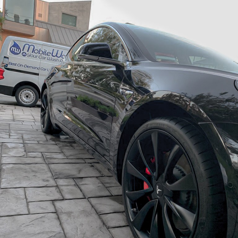 A black Tesla with black rims after a MobileWash mobile car detailing service and pristine car cleaning.